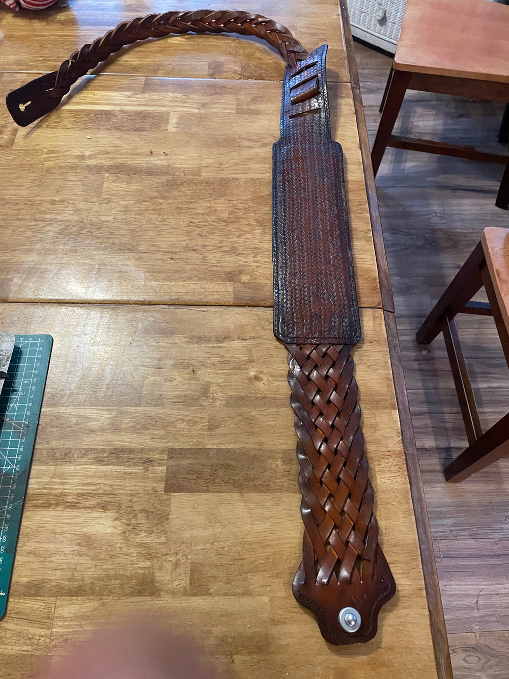 Braided leather guitar strap with a textured shoulder pad.